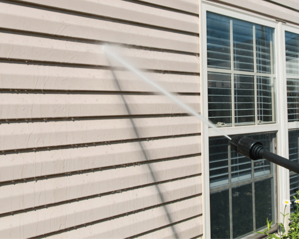 Pristine Properties crew softwashing house siding with professional equipment